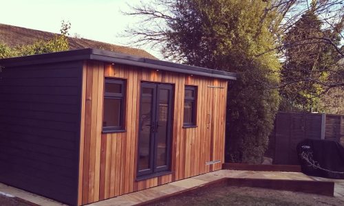 Orchard Garden Room in St Albans - Interior (Outside View with black siding and a stylish wooden deck Project Slider4)