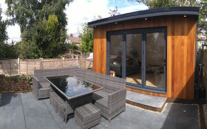 The Grange Garden Room in St Albans - Exterior (A Patio With a Table And Chairs Next To a Wooden Building)