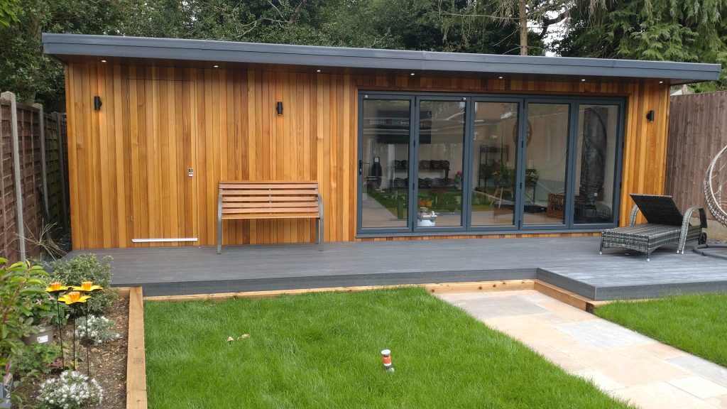 A serene garden room with wooden decking surrounded by a wooden fence, ideal for relaxation