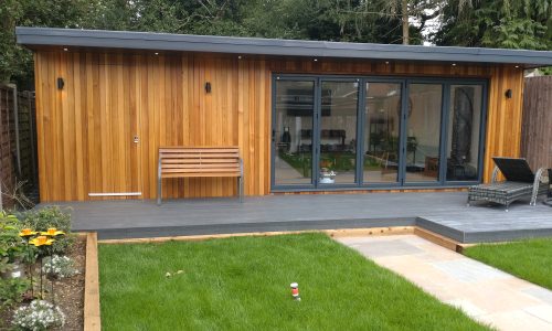 A serene garden room with wooden decking surrounded by a wooden fence, ideal for relaxation