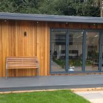 A serene garden room with wooden decking surrounded by a wooden fence, ideal for relaxation