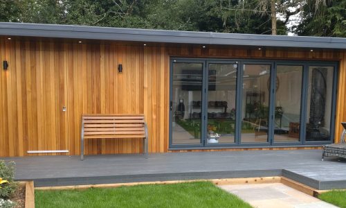 A serene garden room with wooden decking surrounded by a wooden fence, ideal for relaxation