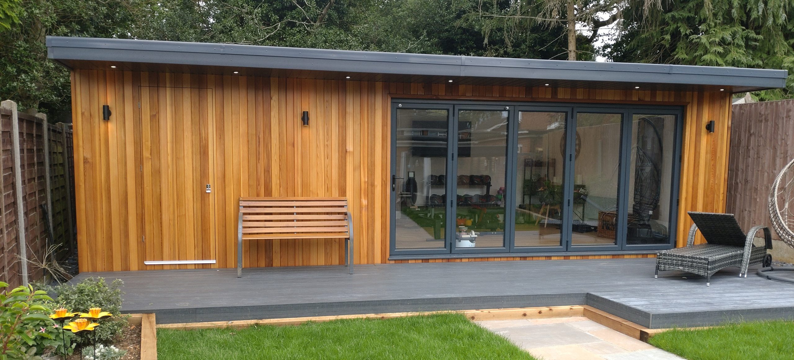 A serene garden room with wooden decking surrounded by a wooden fence, ideal for relaxation