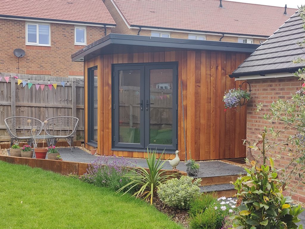 The Mallard Garden Room In St Albans - Outcome (After Construction, Showcasing The Completed Garden Room With A Wooden Exterior, Landscaped Garden, And Outdoor Seating Area)
